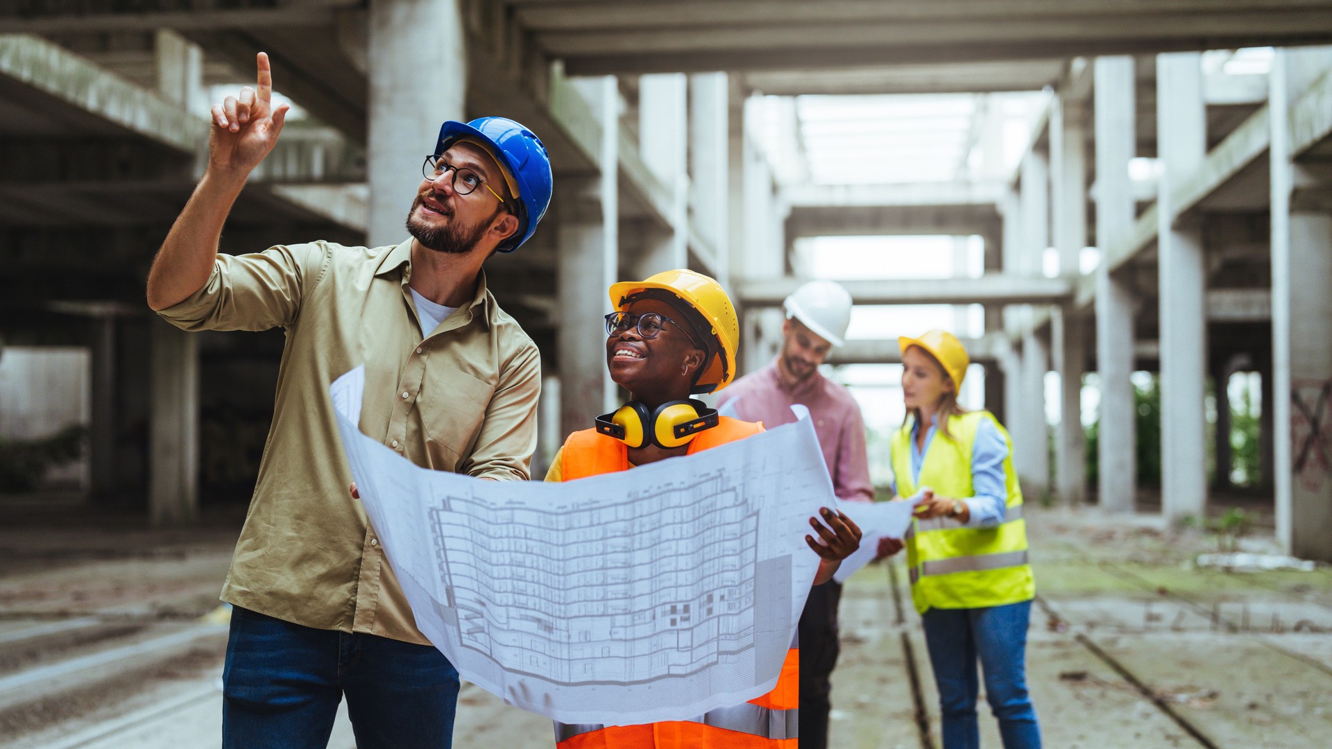 Team of architects and civil engineers inspecting construction site.