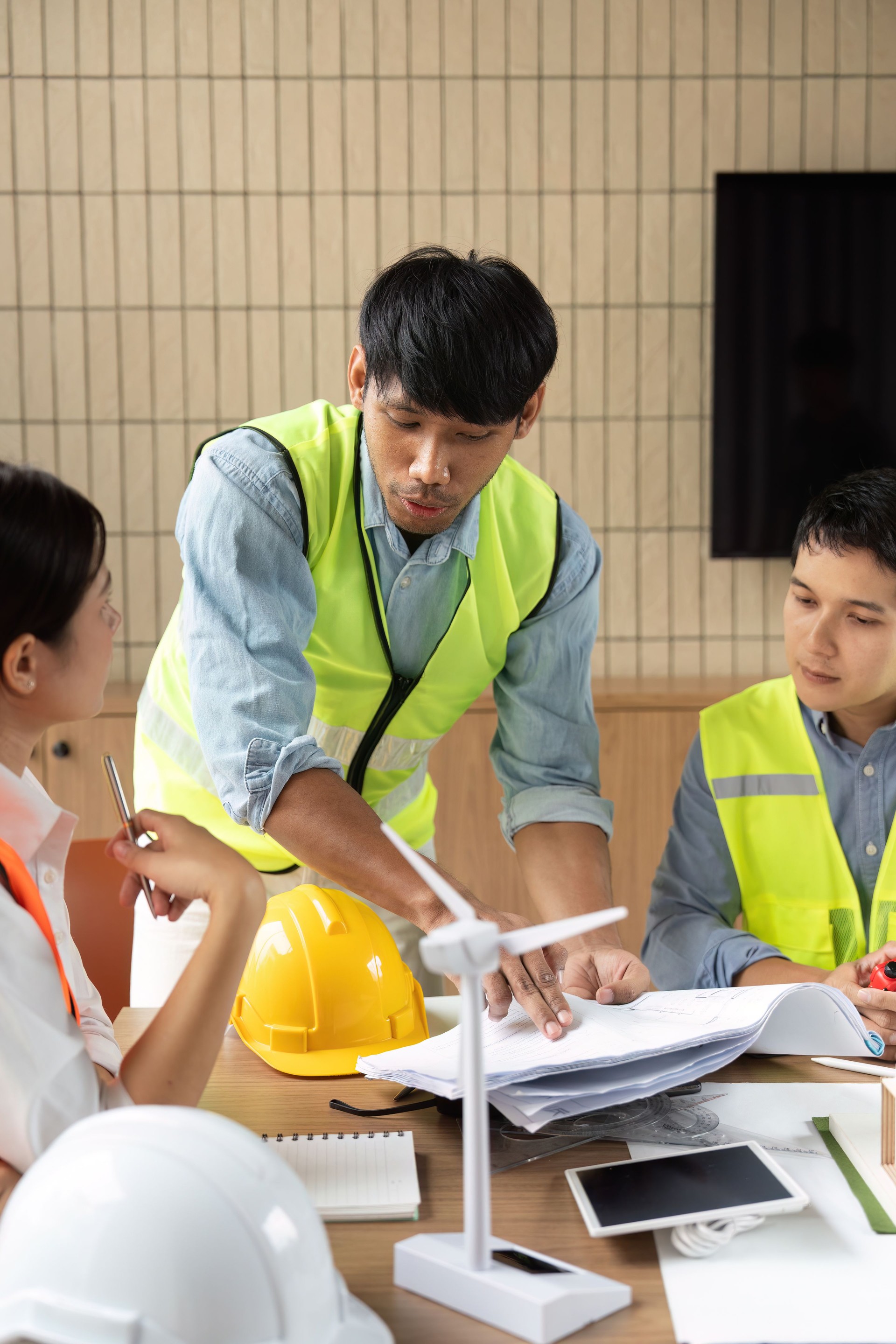 Sustainability and Engineering Discussion. An engineer explaining project details to colleagues in a collaborative setting.